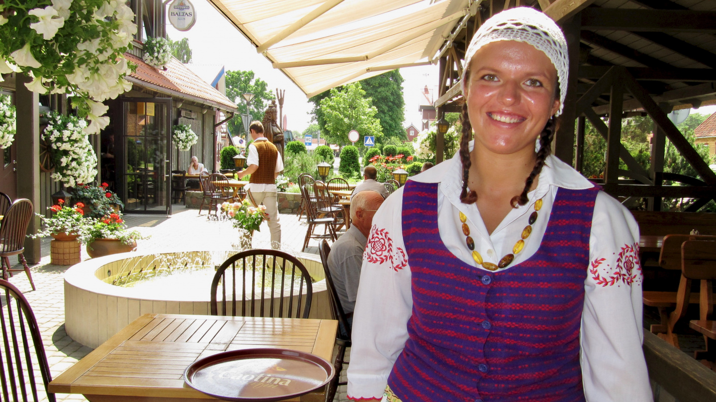 Waitress wearing the traditioonal dress of Nida