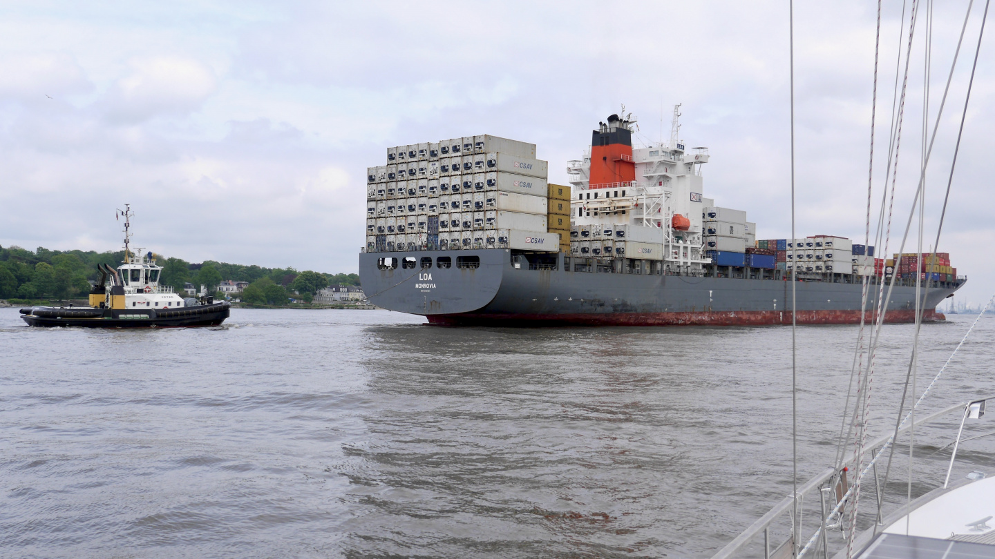 Tug assisting container ship in the port of Hamburg