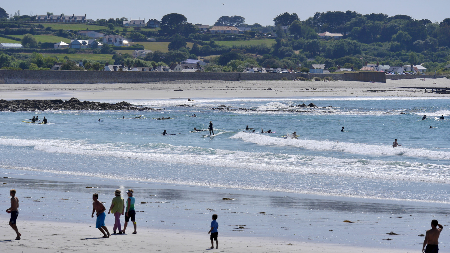 Surfers on the northwest coast of Guernsey