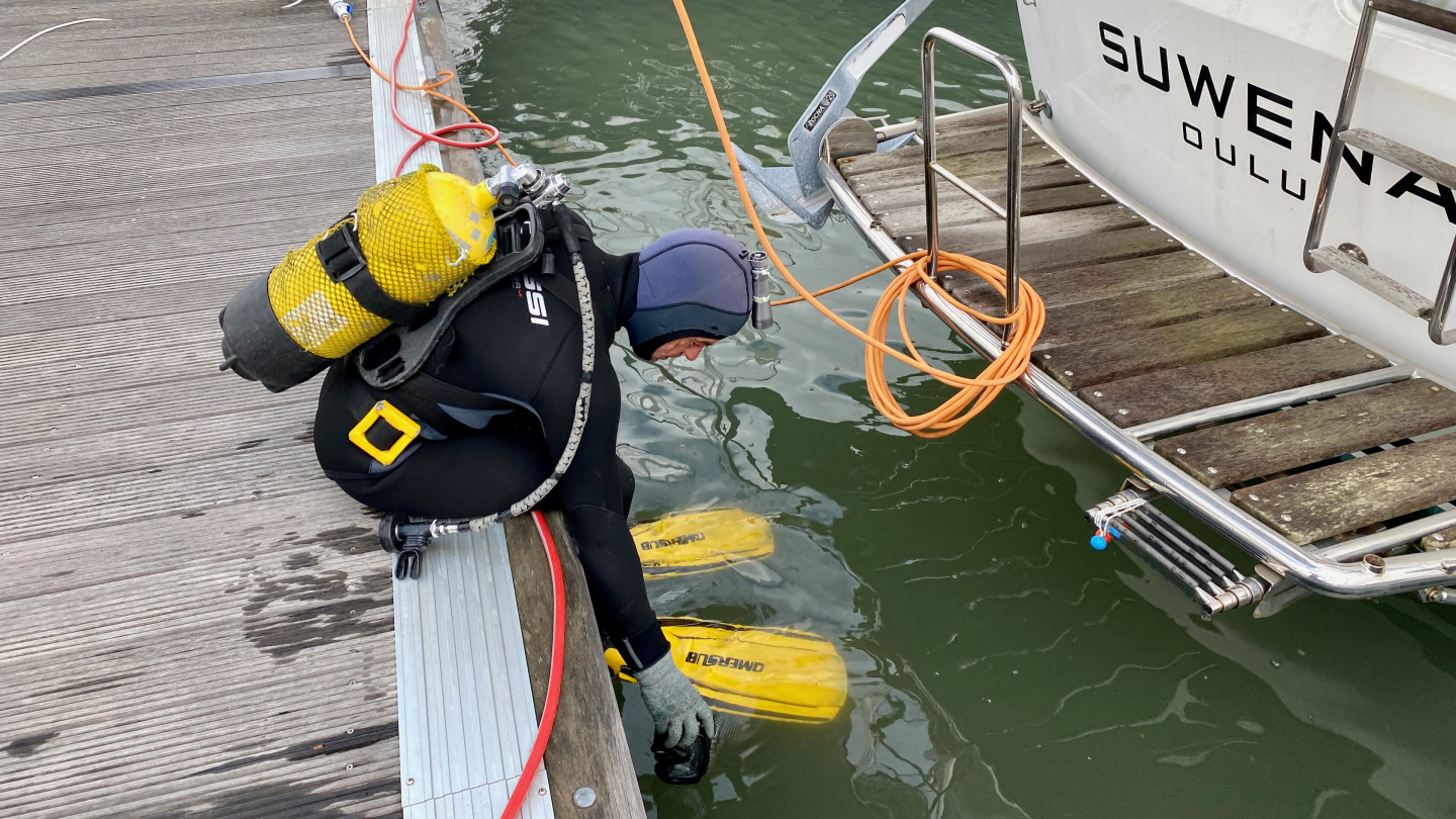 Diver about to clean Suwena's hull in Marina Parque das Nações, Lisbon