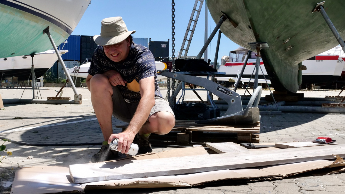 Andrus painting the fender plank in Algés, Portugal